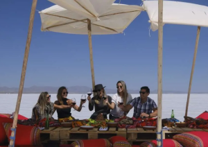 Grupo de pessoas brinda com vinho durante almoço ao ar livre no Salar de Uyuni, Bolívia